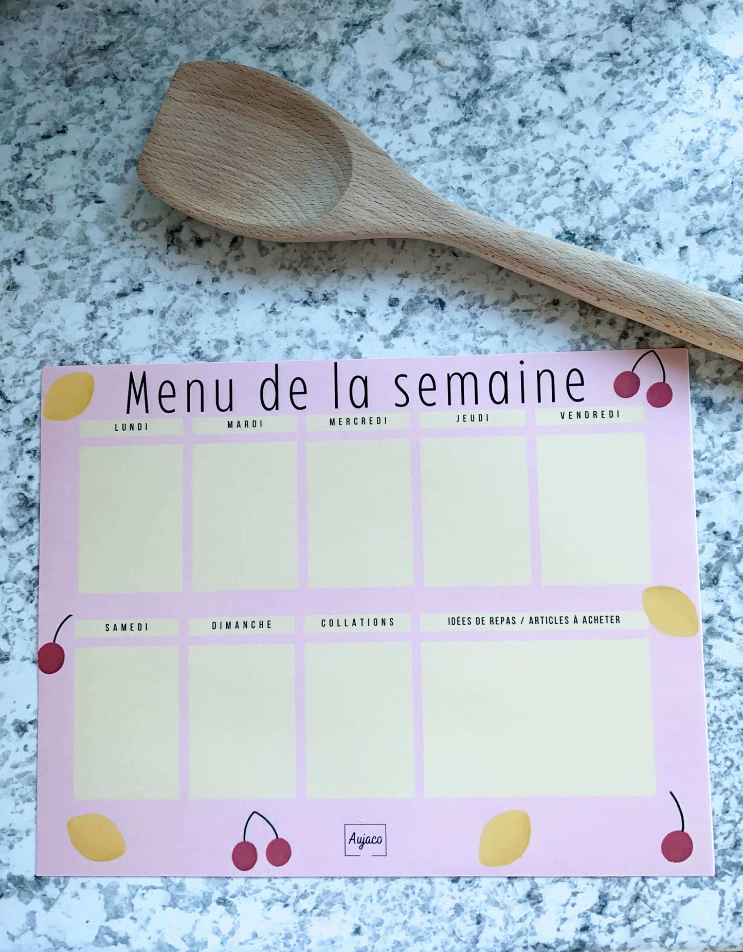 alt="Planificateur de repas Citrons et Cerises avec design rose orné de citrons jaunes et de cerises rouges, format compact 8.5 x 11 pouces, 40 pages, sections dédiées pour chaque jour de la semaine et collations, grand espace pour noter les repas et articles à acheter, option d'ajouter des aimants pour le réfrigérateur, papier cartonné épais"