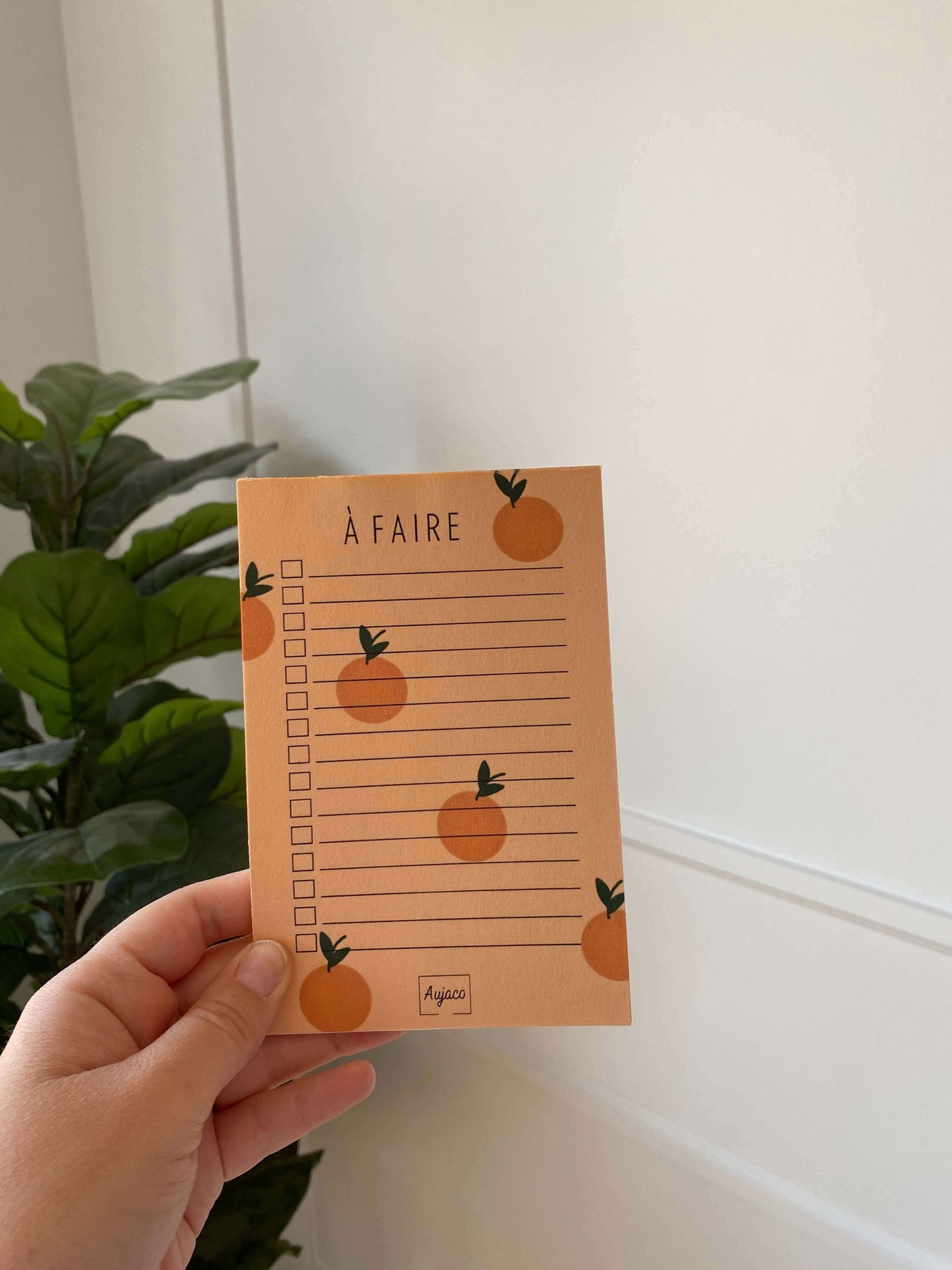 alt="To-do list avec design sur fond orange agrémenté de petites oranges, format compact 4 x 6 pouces, plusieurs cases à cocher pour les tâches, papier cartonné épais pour une meilleure durabilité, 40 pages, dessiné et produit par Aujaco."
