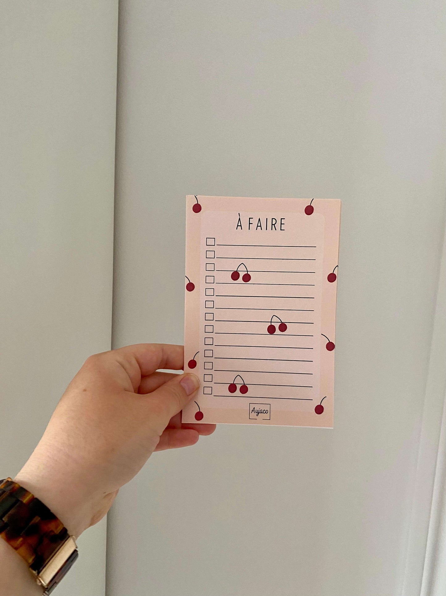alt="To-do list 4x6 pouces par Aujaco, design unique et coloré avec une multitude de cerises rouges sur fond pêche. Format compact avec plusieurs cases à cocher. Papier cartonné épais avec 40 pages."