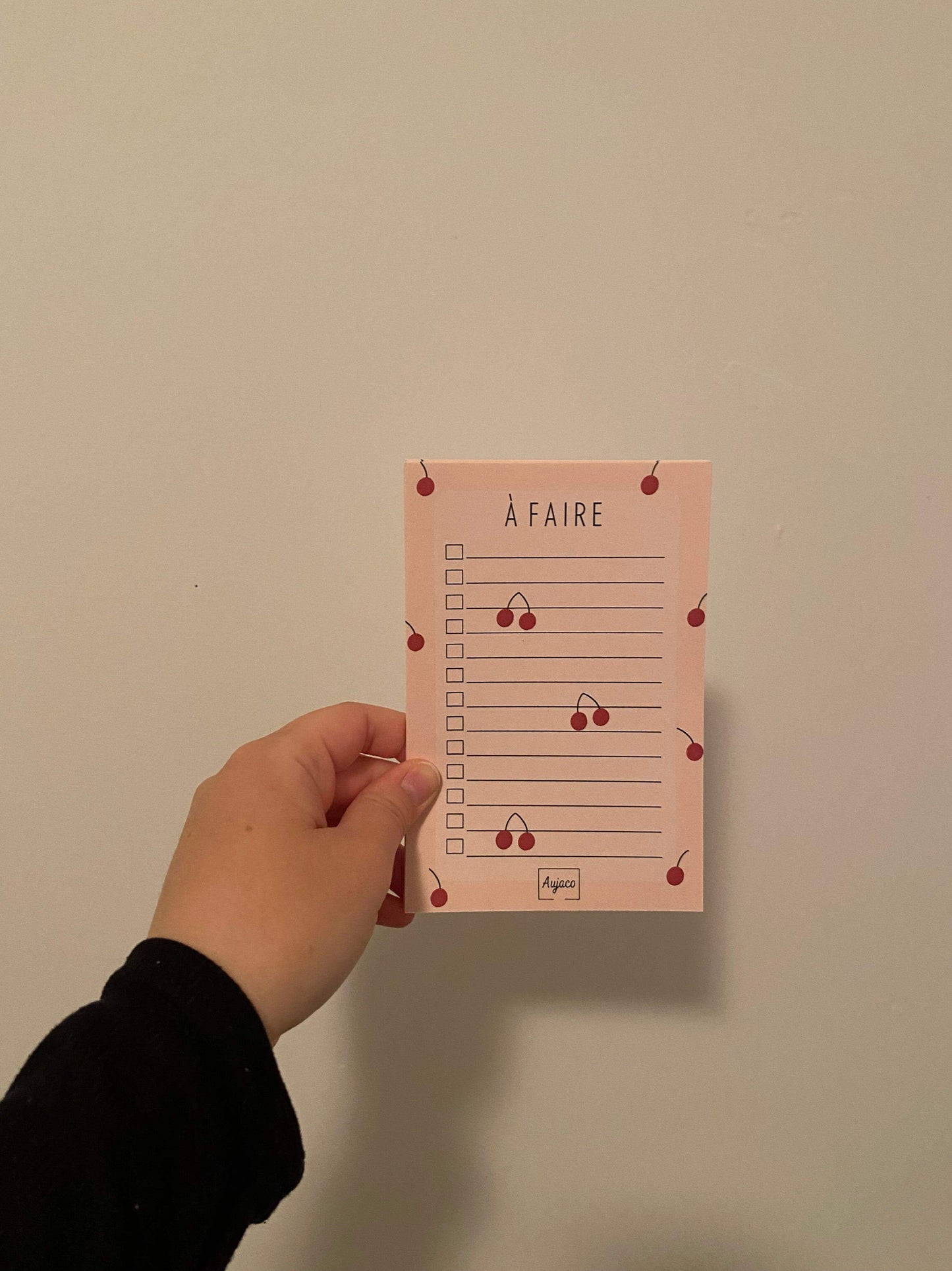 alt="To-do list 4x6 pouces par Aujaco, design unique et coloré avec une multitude de cerises rouges sur fond pêche. Format compact avec plusieurs cases à cocher. Papier cartonné épais avec 40 pages."