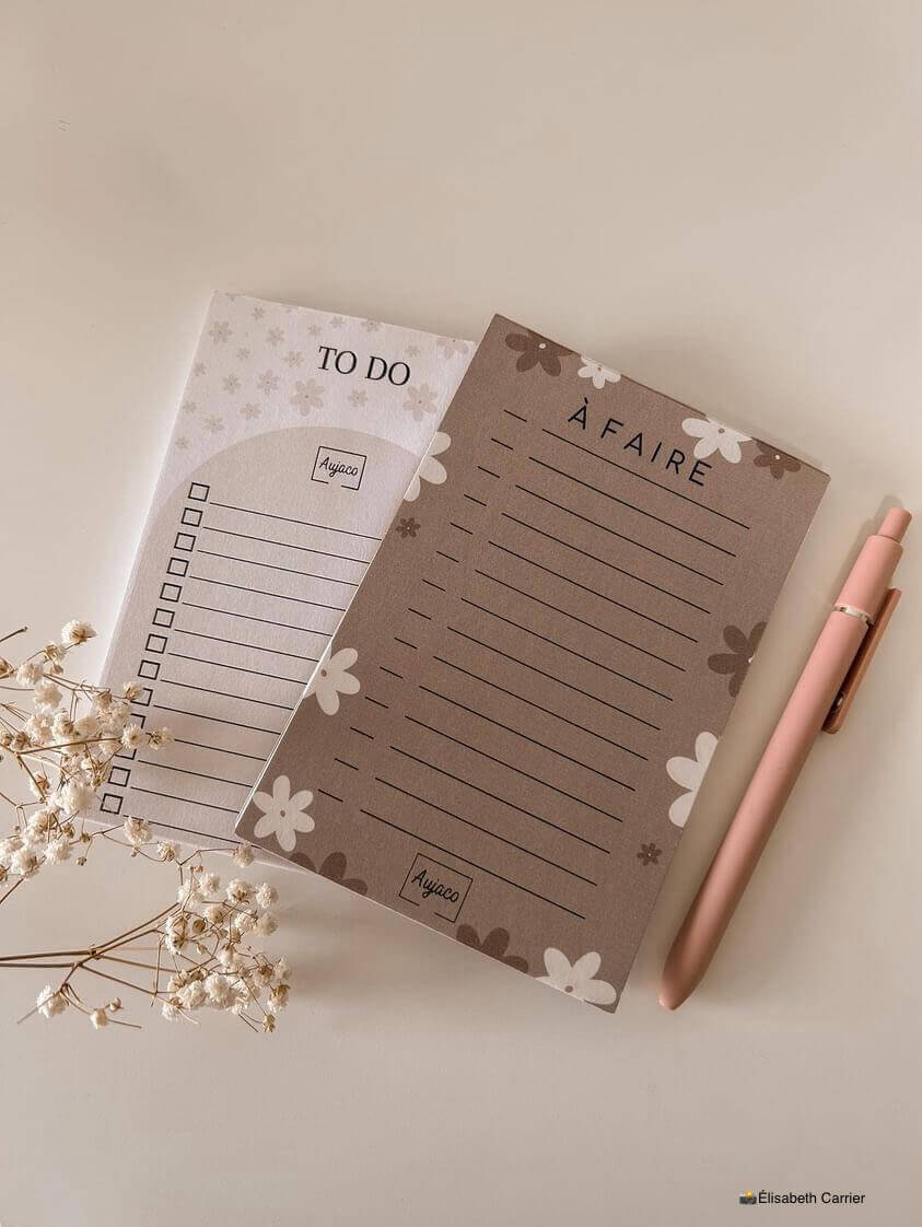 alt="To-do list 4x6 pouces par Aujaco, design simple avec fleurs blanches et beiges sur fond beige chaud. Format compact avec plusieurs cases à cocher. Papier cartonné épais avec 40 pages."