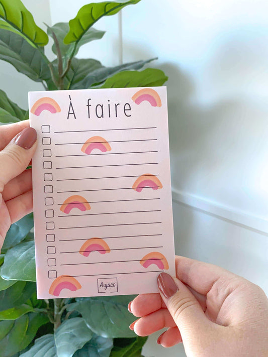 alt="To-do list 4x6 pouces par Aujaco, design unique avec une multitude d'arcs-en-ciel sur fond pêche. Format compact avec plusieurs cases à cocher. Papier cartonné épais avec 40 pages."
