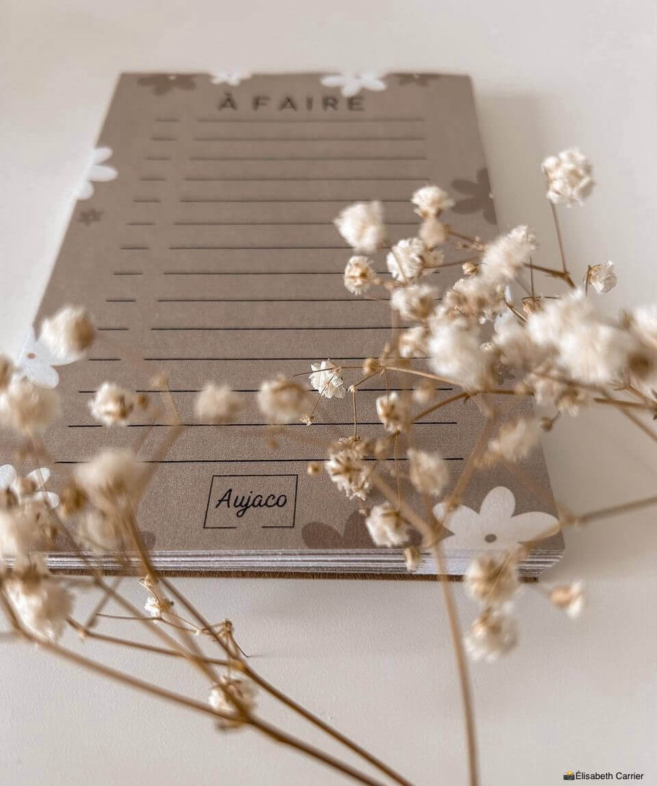 alt="To-do list 4x6 pouces par Aujaco, design simple avec fleurs blanches et beiges sur fond beige chaud. Format compact avec plusieurs cases à cocher. Papier cartonné épais avec 40 pages."